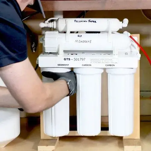 Technician installing a reverse osmosis water filtration system