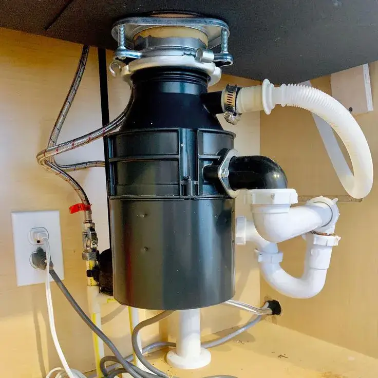 New garbage disposal installed with a dishwasher drain hose and P-trap