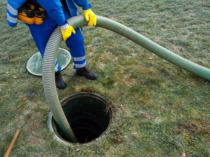 Technician servicing an outdoor sewer access point