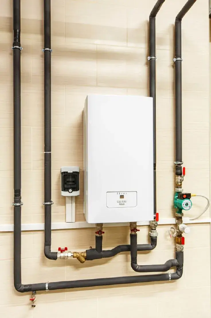 Wall-mounted commercial water heater with insulated piping