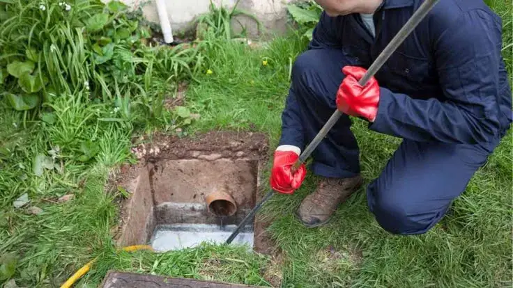 Technician clearing an outdoor drain line