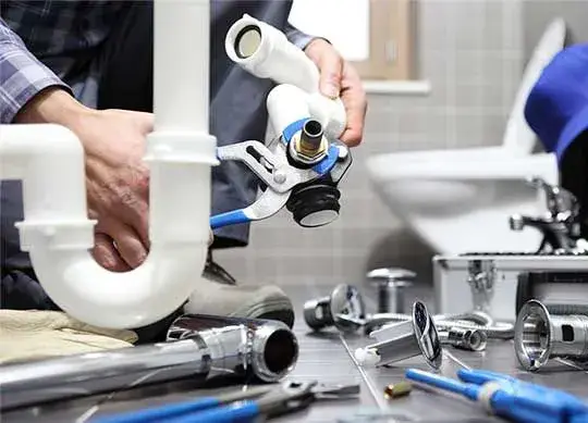 Plumber clearing a bathroom sink P-trap
