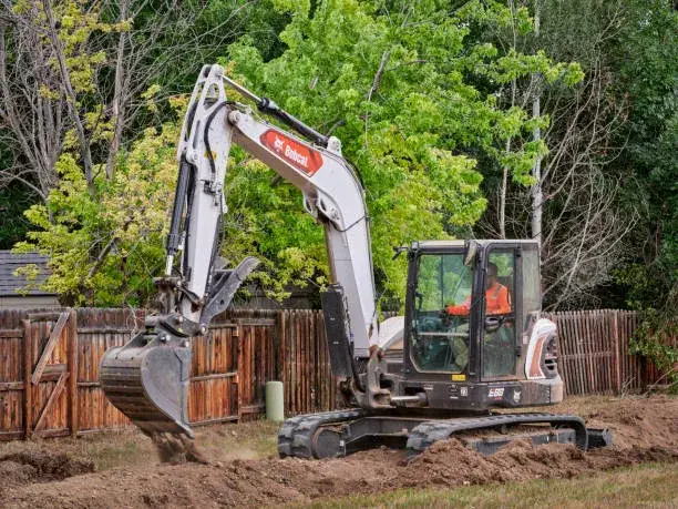 Excavator performing underground utility excavation